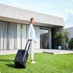 BLUETTI Elite 320 Powerstation mit Transportgriff vor modernem Wohnhaus im Outdoor-Einsatz