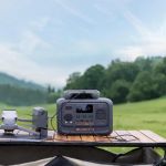 Kompakte BLUETTI Premium 30 V2 Tragbare Powerstation lädt den Akku und die Remote Control einer DJI Drohne in den Bergen.